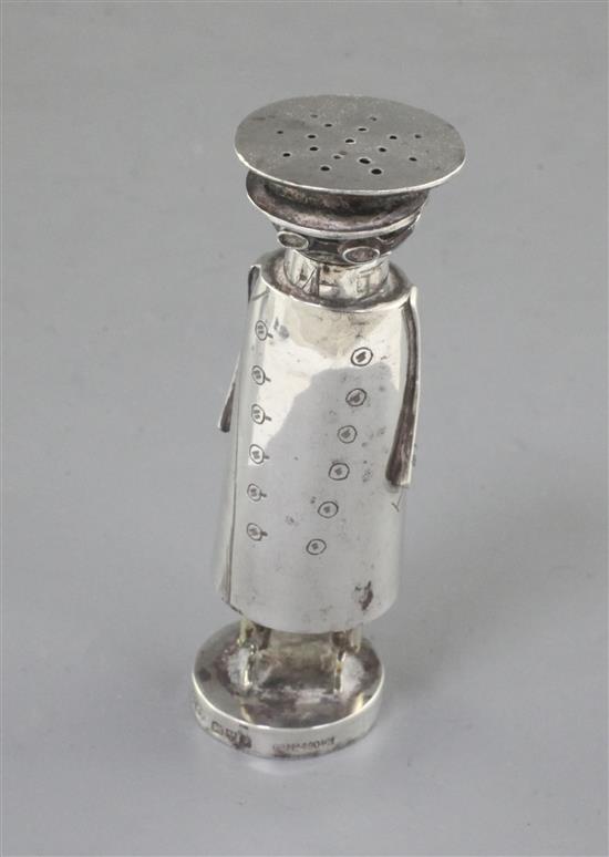 An Edwardian novelty silver pepperette in the form of a motorist, Saunders & Shepherd, 85mm.